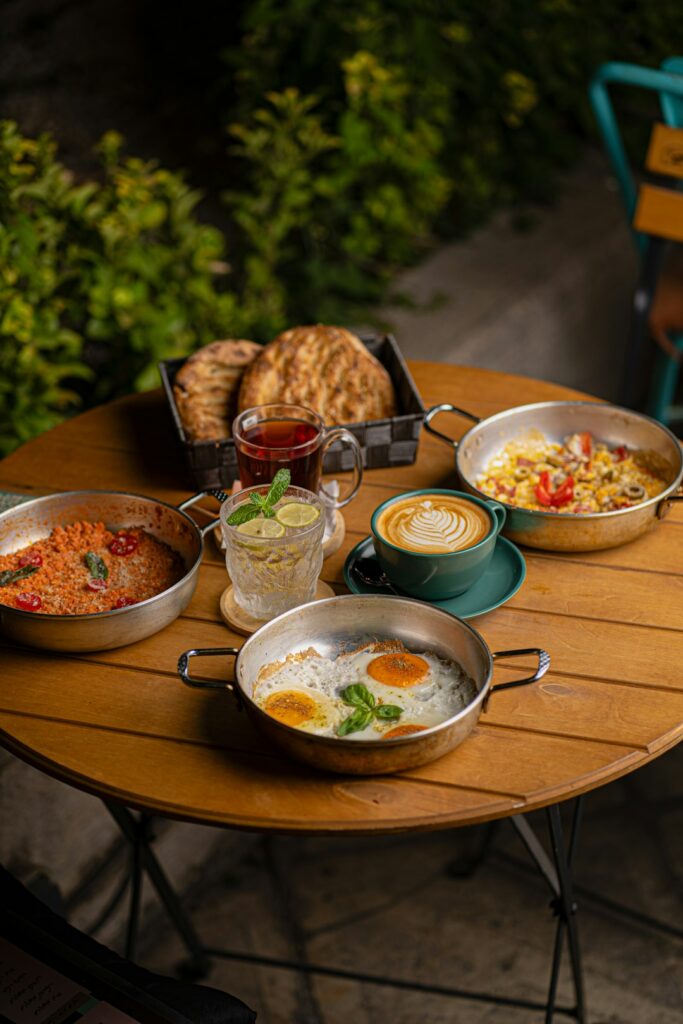 A table laden with breakfast dishes, tea, and coffee
