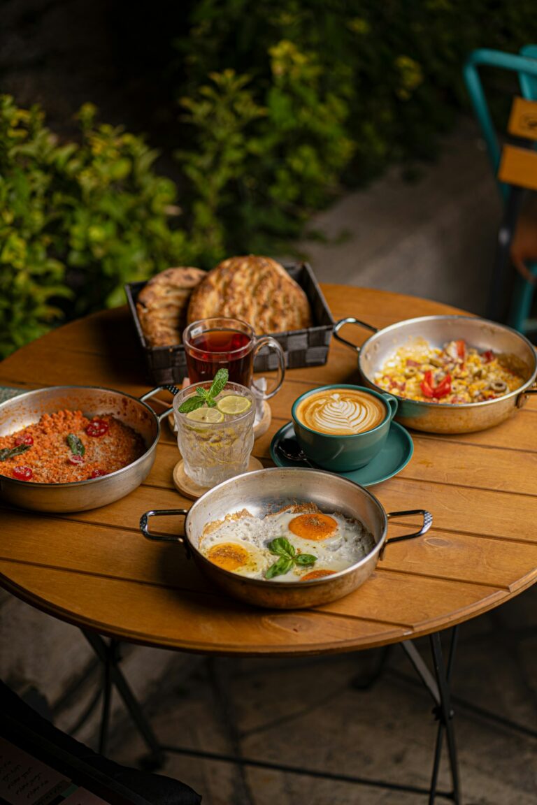 A table laden with breakfast dishes, tea, and coffee
